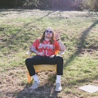 a man in a baseball jersey sitting in a yellow chair